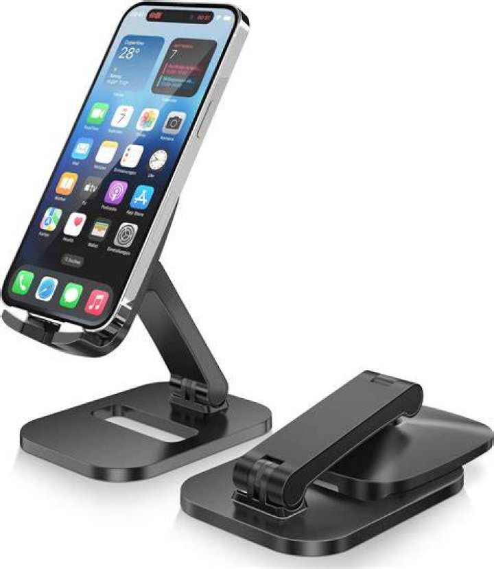 iPhone on a desk with a Mac computer, camera, and stationary